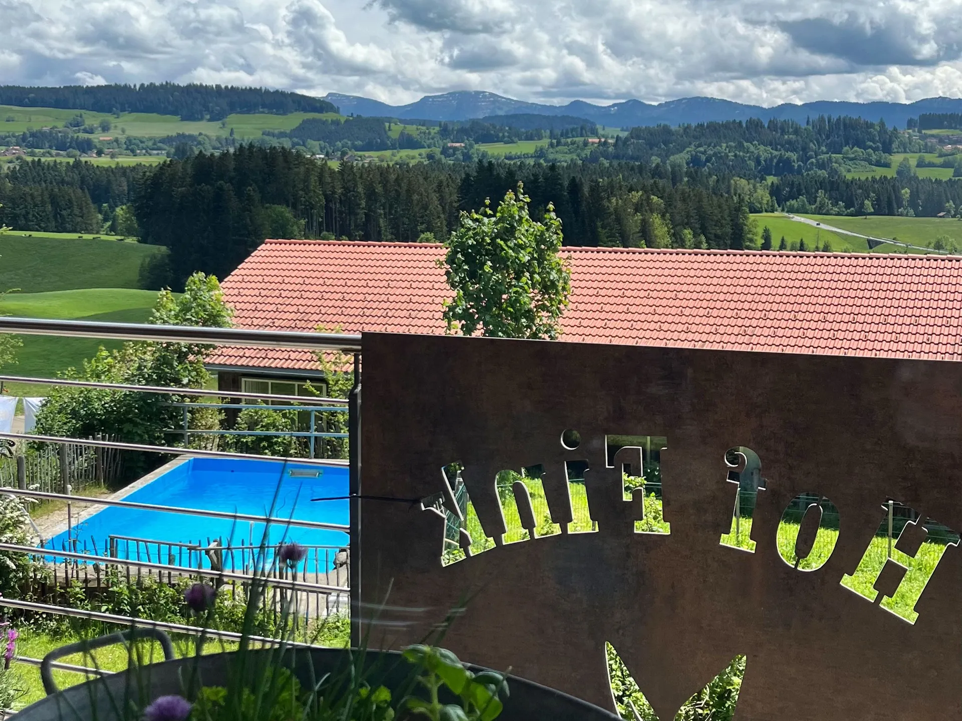 Blick vom Hof über Wiesen und Wälder zu den Bergen